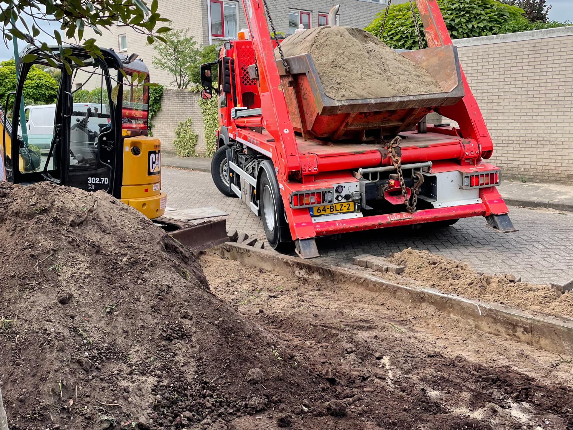 Aanvoeren van zand en afvoeren van grond.